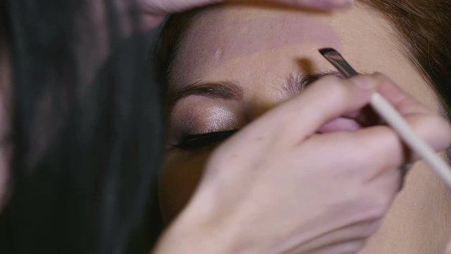 4K. Makeup process  of young woman model before photographing. Face close up