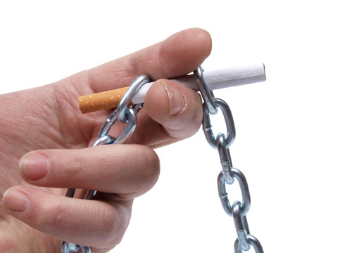 Cigarettes and hand with chain on white background