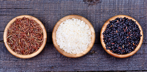 Various types of rice in a bamboo bowl on table