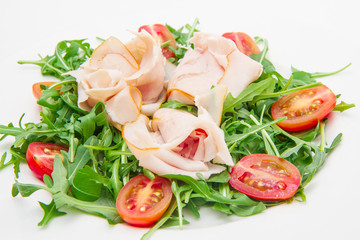 ham slices on a bed of arugula and cherry tomatoes
