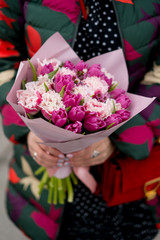 Flowers bouquet with tulips in woman's hands