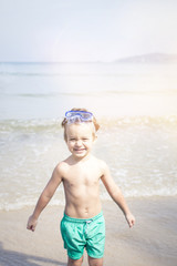 cute little boy with diving glasses at the beach