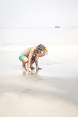 cute little boy with diving glasses at the beach
