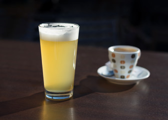glass of beer and a cup of coffee on the cafe table
