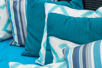 Colorful pillows on a blue sofa. White, blue, dark blue.