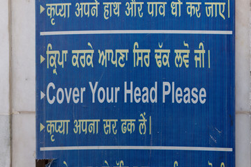 Information board at the entrance to the Golden Tempe in Amritsar, India: Cover your head