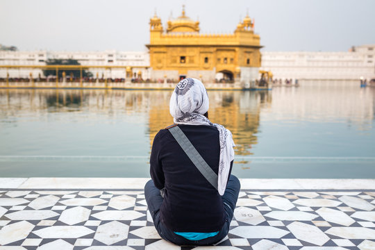 Girl sitting front of the Golden Temple in Amritsar, India