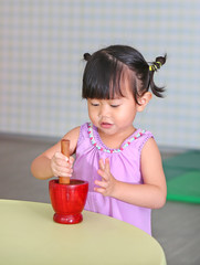 Asian Child girl play for make the green papaya salad or 