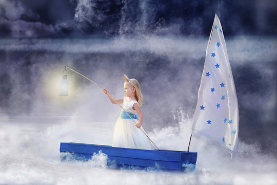 Fairytale photography. A girl sailing on a boat in the fog. Keeps the light in the hands.