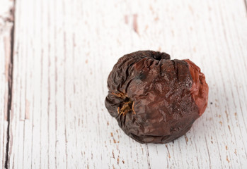 Photo of a rotten apple on wooden