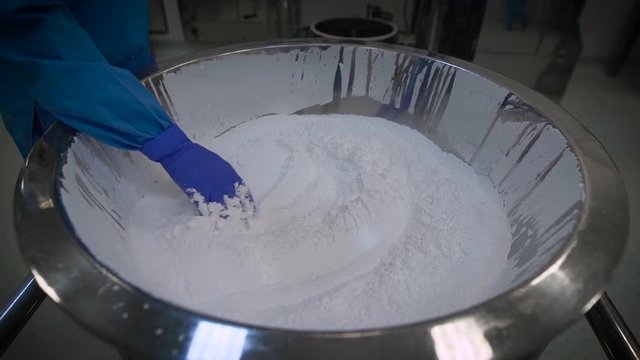 During the manufacturing process at a chemical plant control kompanentov purity. Specialist in haschitnom suit and glove evaluates the quality of the mixture