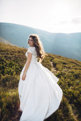 Fototapeta na wymiar Cheerful bride runs over green autumn hill
