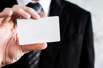 Fototapeta premium Close up of businessman holding white blank card.