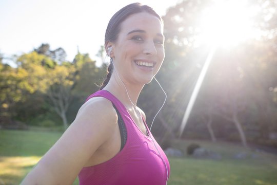 Portrait of smiling female jogger listening to music