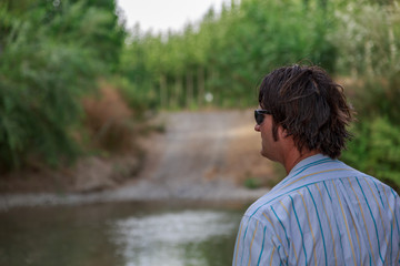 A man observes nature from the side of a river