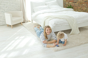 A woman with a child at home playing on a tablet 