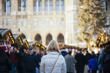 Beautiful girl in the Christmas market, back view