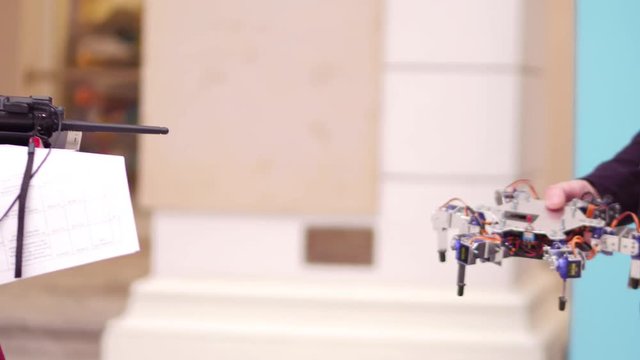 Young man holding his DIY hexapod robot. 4K shot