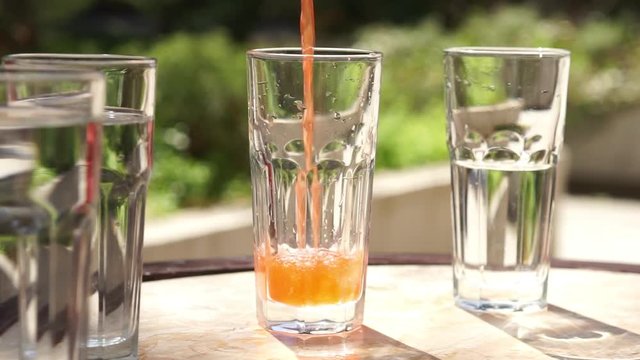 Pouring red juice in a glass beaker. Container filled with juice. Slow motion full HD video footage 1920x1080