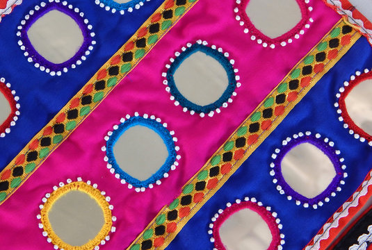 lepo embroidery work on clothes stitching pieces of mirror, decorative beads and coins on clothes by Indian tribal banjara or lambadi people