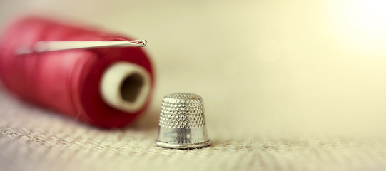 Hobby, diy concept - old needle, thread and thimble