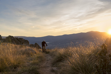 Cyclist on the mountain at sunset
