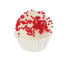 Cake ball in white glaze with red sprinkles in paper form