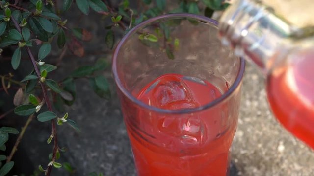 Pouring red juice in a glass beaker. Container filled with juice. Slow motion full HD video footage 1920x1080