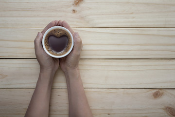 love coffee cup with Heart shape in hand on table