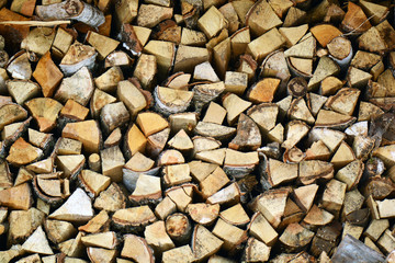 Natural wooden background, closeup of chopped firewood. Firewood stacked and prepared for winter Pile of wood logs. Chopped firewood on a stack.