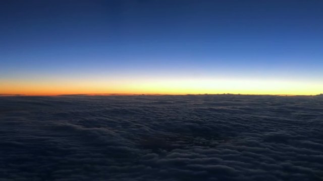 Beautiful sunset flying above the clouds, view from the airplane