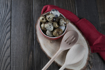 Quail eggs in red pot and kitchen tools. Healthy  food concept on wooden table