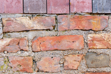 Old uneven raw varied color brick construction with new layer of blocks