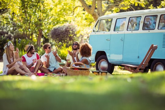 Group of friends having fun together near campervan