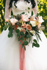 Wedding gentle disheveled bouquet of peach shades with pink ribbon