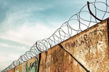 Barbed wire fence detail against of the blue sky taken closeup.