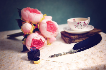 Vintage feather pen and bottle of ink on table 