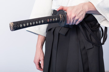 Hands holding the Katana on white background.