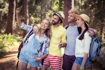 Group of friends taking selfie with mobile phone