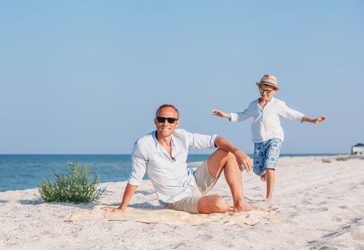 Family vacation time - father and little son relax on the sea coast