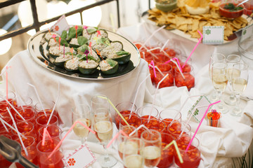 glasses with champagne. catering banquet table. a lot of snacks and canapes