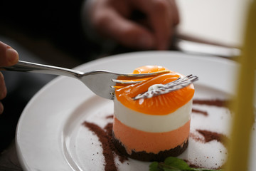 Passion fruit cake, mousse dessert on a white plate with cup of tea. Top view