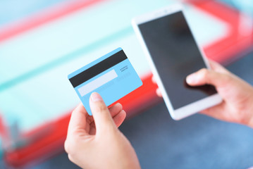 People using credit card and smart phone paying online.