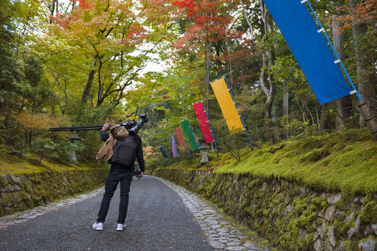 Photographer in Japanese garden in Kyoto during autumn