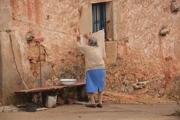 Obraz na płótnie Canvas anciana tendiendo ropa