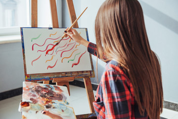 Pretty Pretty Girl artist paints on canvas painting on the easel.