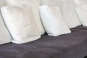 Fototapeta na wymiar Close up white pillow on the brown sofa