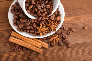 Coffee beans and cinnamon on a background of burlap. Roasted coffee beans background close up. Coffee beans pile from top with copy space for text. Seasoning. Spice. Cinnamon. Badian. Coffee house.
