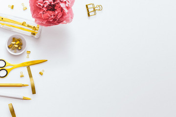 Desktop flatlay hero image, with gold stationery accessories and pink peony flower on a plain white...