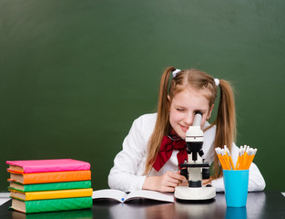 Girl examining preparation under the microscope